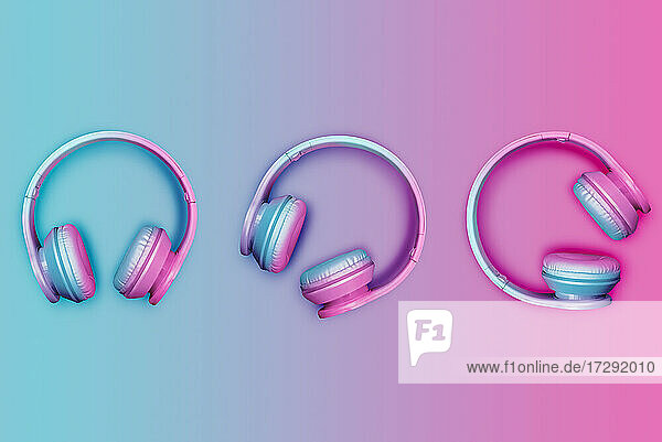 Studioaufnahme von drei Paar rosa und blauen kabellosen Kopfhörern