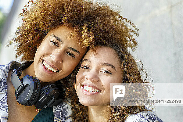 Lächelnde junge Freundinnen zusammen
