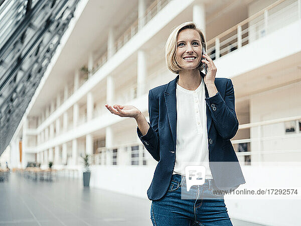 Geschäftsfrau lächelnd im Gespräch auf dem Handy im Büro Lobby