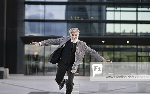 Cheerful businessman in front of office building