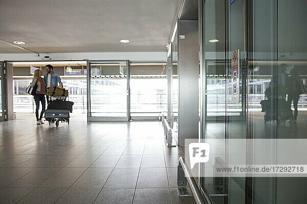 Junges Paar mit Gepäckwagen im Flughafenterminal