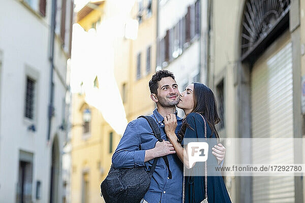 Weibliche Touristin küsst Mann auf der Straße in der Stadt