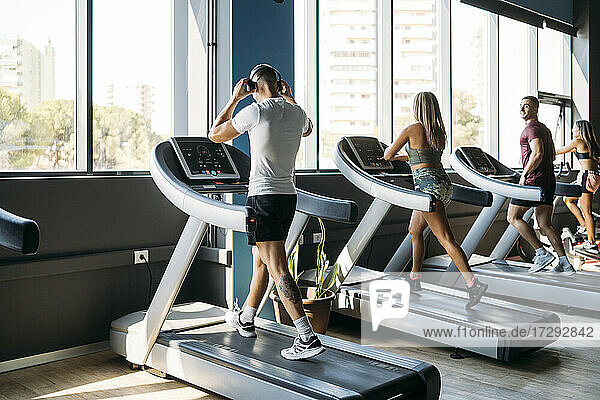 Male and female athlete exercising on treadmill at health club