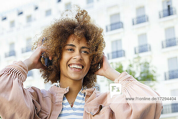 Glückliche junge Frau beim Einstellen der Kopfhörer