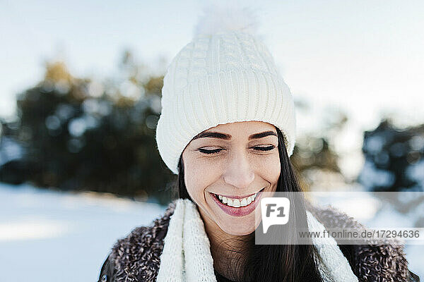 Lächelnde Frau mit Strickmütze im Winter