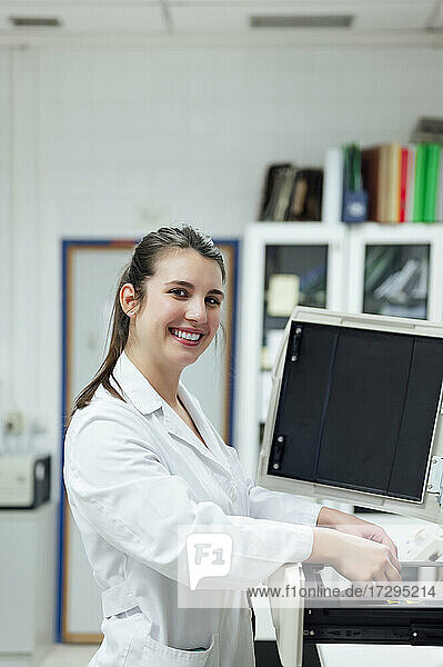 Lächelnde junge medizinische Expertin bei der Arbeit im Labor