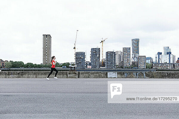 Aktive Sportlerin beim Laufen auf der Promenade in der Stadt
