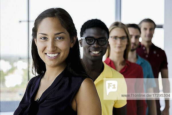 Lächelnde weibliche und männliche Kollegen im Streit im Büro