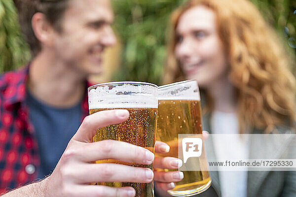 Man and woman toasting beer glasses at pub