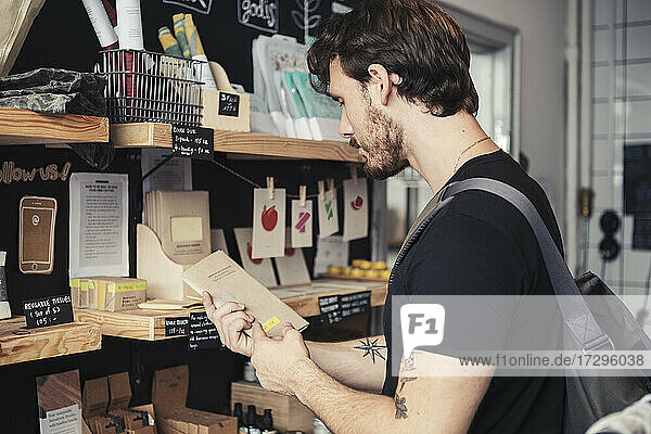 Male customer reading package at organic shop