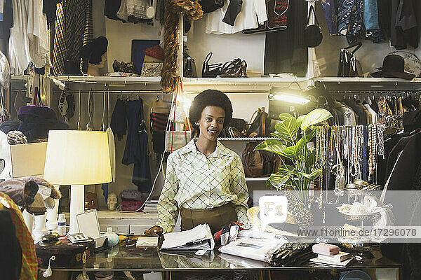 Portrait of female owner standing at counter in boutique