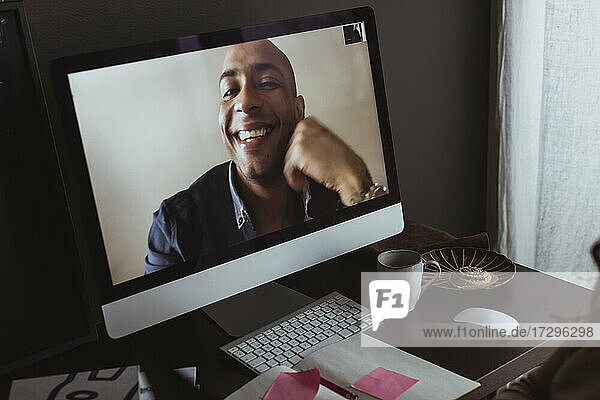 Lächelnder Geschäftsmann auf dem Computerbildschirm während eines Videoanrufs