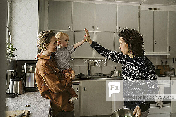 Frau mit Tochter gibt Mutter in der Küche zu Hause High-Five