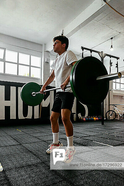 Athletischer Junge beim Crossfit-Training im Fitnessstudio