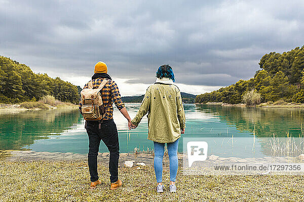 Tourist couple in nature contemplating beautiful views of a lake