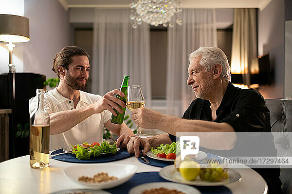 Young and aged man proposing toast