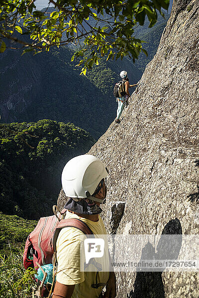 Ein paar Kletterer auf einem felsigen Berg im Regenwald im Tijuca-Park