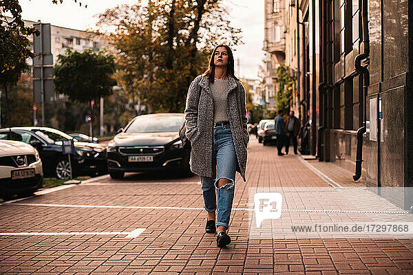 Thoughtful woman walking on street in city