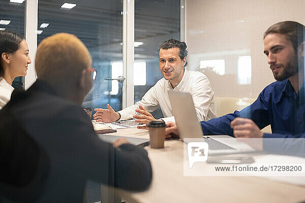 Positive man talking with colleagues during meeting
