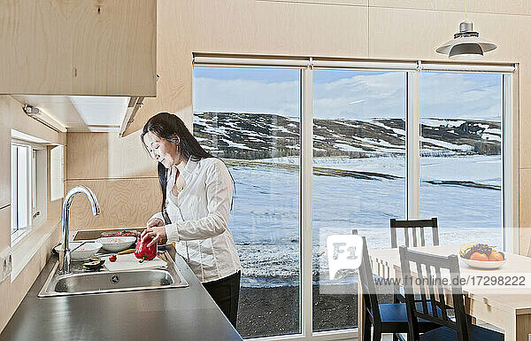 Frau bereitet Essen in isländischem Ferienhaus zu