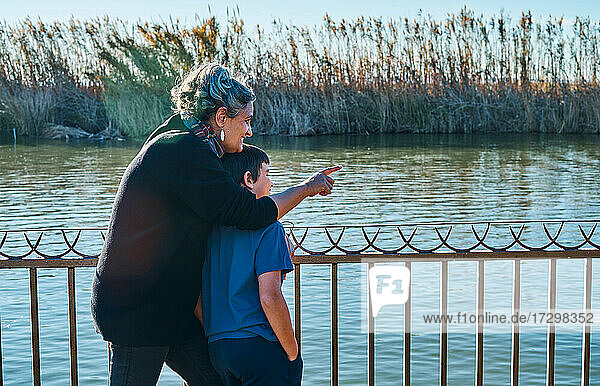 Mother with her son looking at the boats at the lake