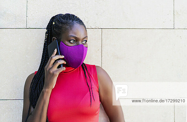 Afrikanische Sportlerin  die auf ihr Smartphone spricht