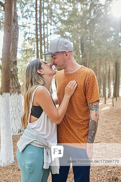 Glückliches verlobtes Paar  das sich mitten im Wald küsst
