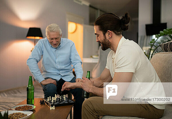 Junger Mann spielt mit Großvater Schach