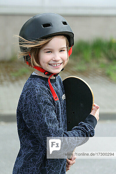 Mädchen mit Skateboard. Porträt eines Mädchens mit einem Helm.