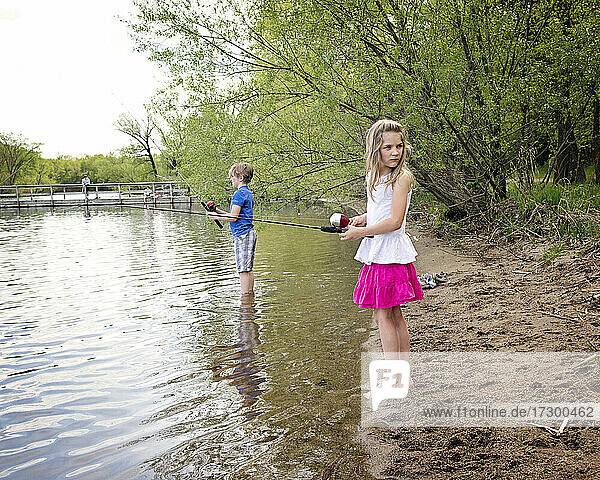Junges Mädchen und Junge beim Angeln am Ufer eines Sees