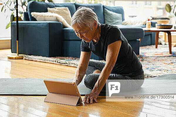 Ältere Frau trainiert und lernt mit digitalem Tablet