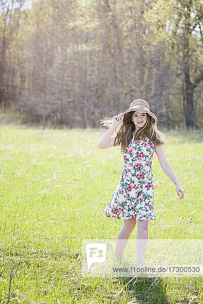 Schönes Teenager-Mädchen im Freien im Sonnenkleid  von hinten beleuchtet.