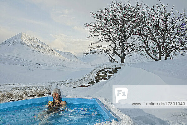 Frau genießt Whirlpool in Skihütte in Island