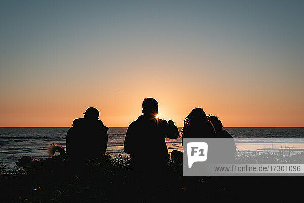 Freunde genießen einen Sonnenuntergang am Strand