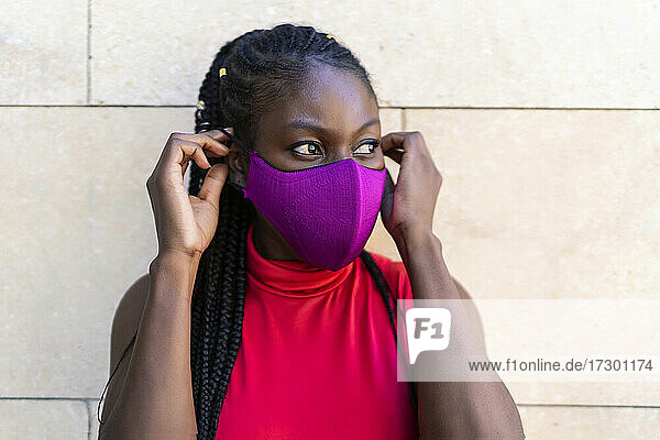 Afrikanische Sportlerin beim Aufsetzen der Maske