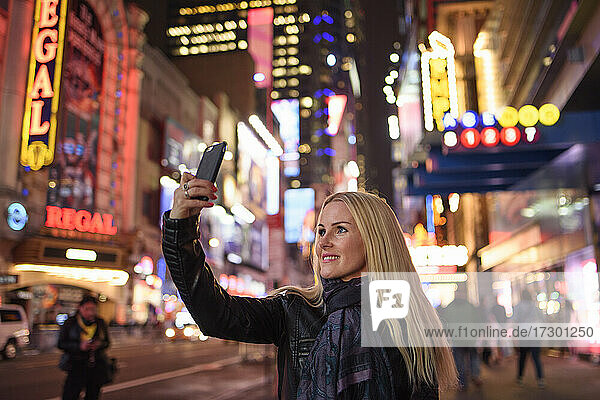 Lächelnde Frau nimmt Selfie in berühmten Stadtzentrum