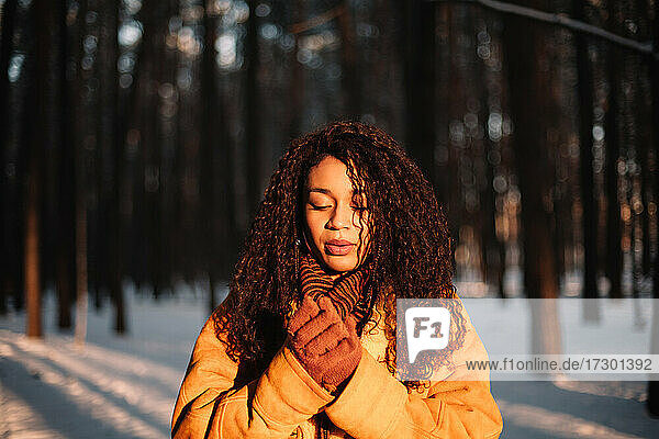 Portrait of beautiful young woman standing in park during cold winter