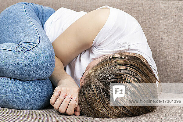 Junge Frau liegt in Fötus- oder Embryo-Stellung. Nahaufnahme