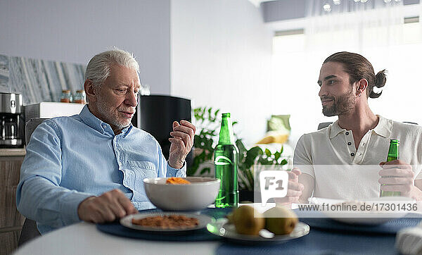Grandfather and grandson talking at table
