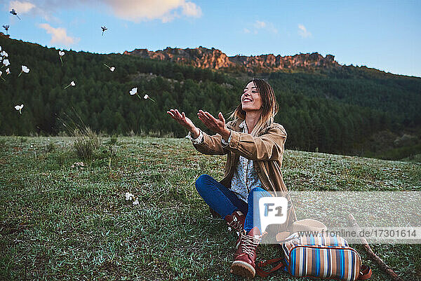 A happy woman in the mountains.She throws some flowers.