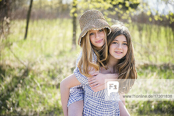 Zwei glückliche junge Teenager-Mädchen in Sonnenkleidern im Freien.