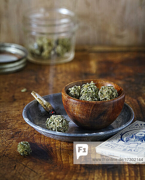 vintage looking cannabis still life with burning joint and flowers