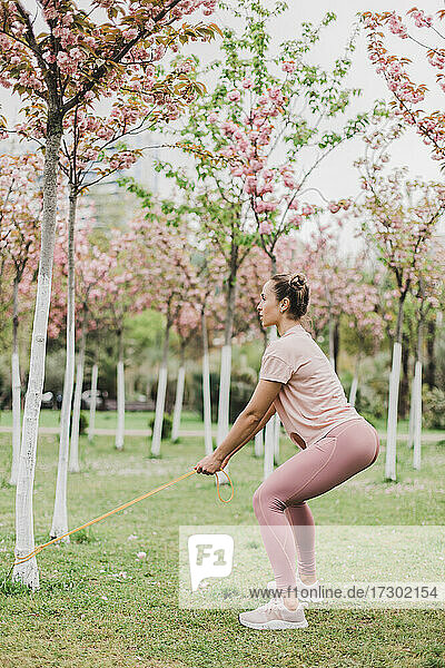 eine junge aktive Sportlerin treibt Sport im Freien zwischen Blumen