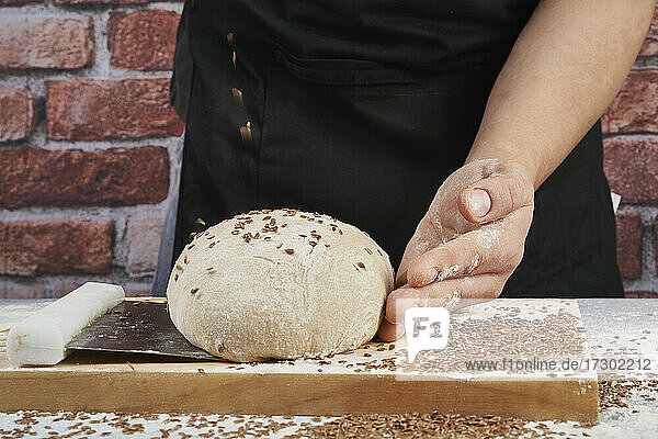 Bäcker fügt Ingwer zu handwerklichem Brotteig hinzu