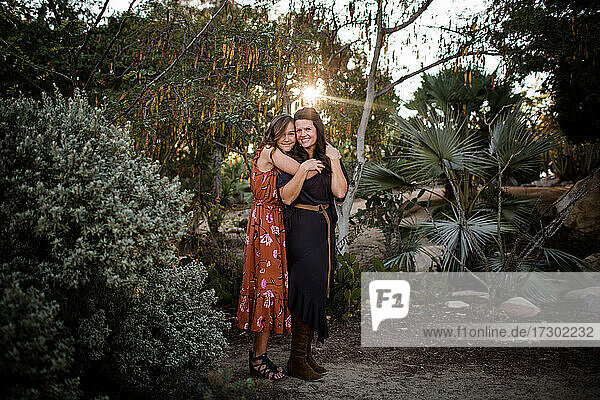 Teenager-Tochter umarmt Mutter im Garten in San Diego