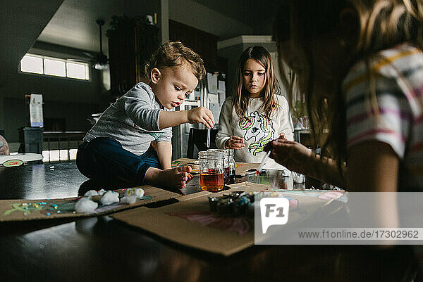 Kinder arbeiten zu Hause an einem Kunstprojekt  bei dem sie Fische herstellen