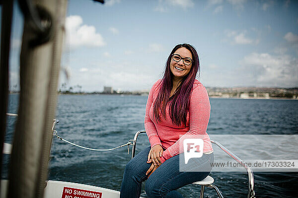 Hispanische Frau in den späten Dreißigern  die auf einem Boot in der Bucht von San Diego sitzt