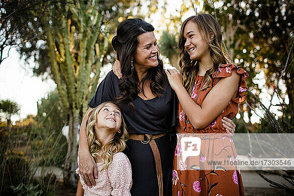 Mutter und Töchter lächelnd im Wüstengarten in San Diego