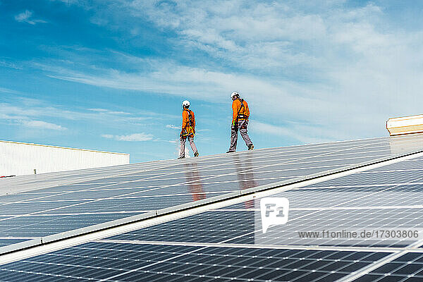 Unrecognizable solar panel technicians cheking a Spanish installation