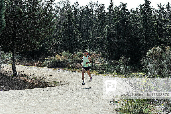 Südamerikanischer Mann läuft auf einem Naturpfad im Wald